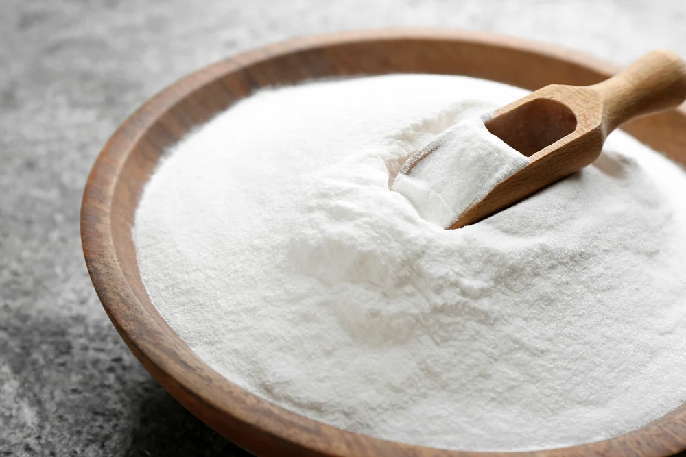 Green pest control ingredient, Boric acid powder, in wooden bowl with wooden scoop